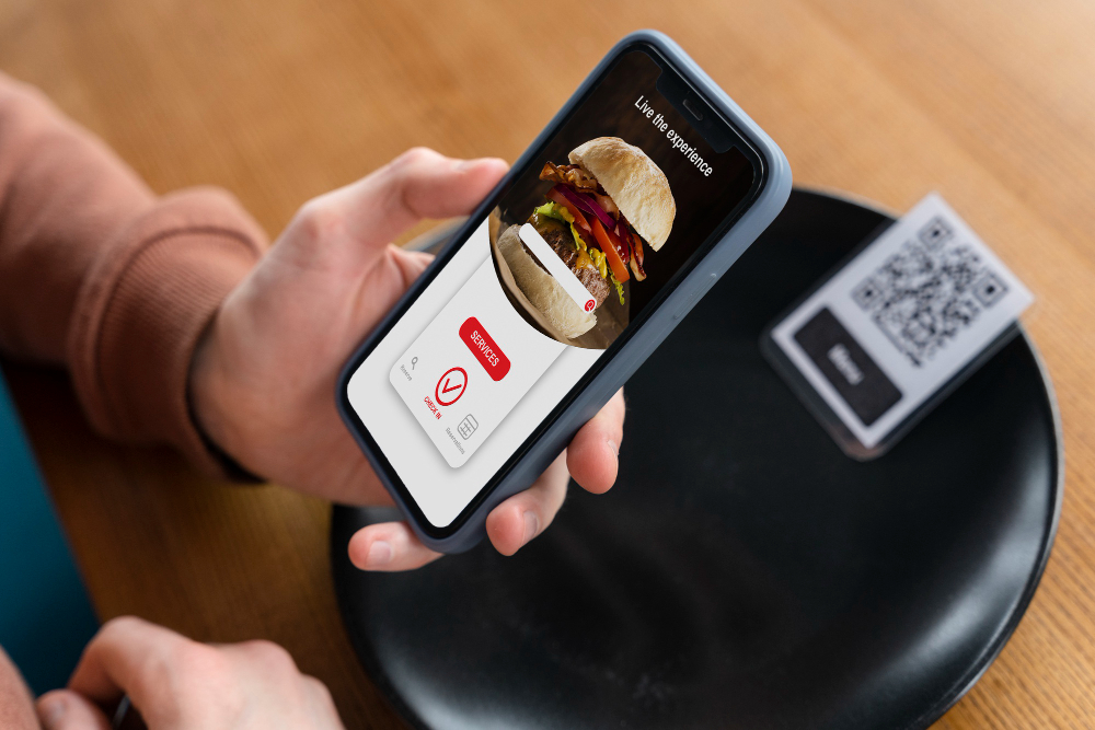 Customer scanning QR code on table with smartphone to access direct online ordering menu at restaurant – representing zero-commission online ordering with Level POS for independent restaurants.